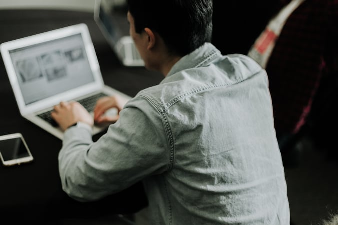 man typing on a laptop