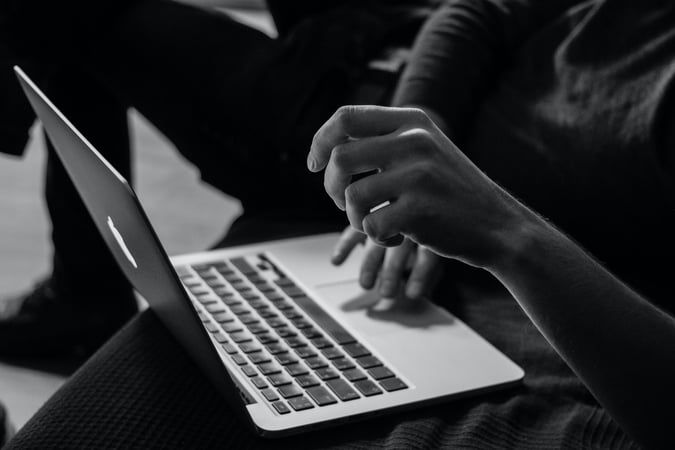 Black and white image of someone typing on a computer